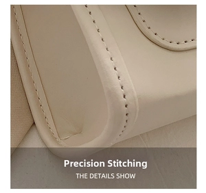 Macro view of the precision stitching detail on cream white leather crossbody bag
