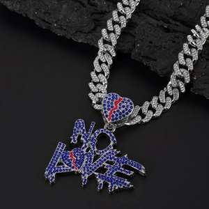 Macro detail of NO LOVE letter pendant on silver Cuban link chain with red lightning motifs