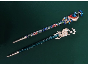 Detailed close-up of peacock cloisonné and gold phoenix hair pins for Hanfu styling