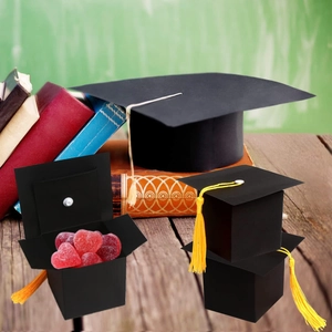 Detail of black graduation cap candy box with yellow tassel and heart-shaped sweets