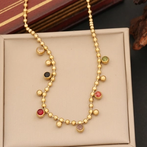 Gold beaded necklace with colorful crystal pendants on a jewelry box lid