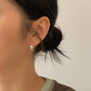 Side view of woman wearing minimalist silver 925 sterling silver crisscross earrings