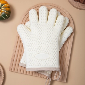 Beige silicone oven mitts with non-slip texture on a wooden board for kitchen baking