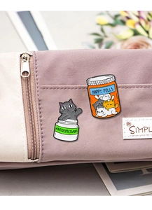 Detail of cute cat antidepressant and happy pills enamel pins on purple canvas bag