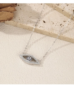 Detailed shot of an evil eye necklace pendant in silver with blue and clear crystals