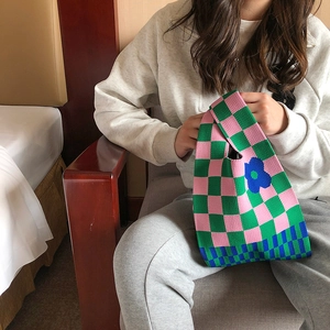 Knitted tote bag with pink and green checkerboard pattern and blue flower detail
