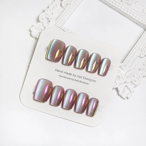 Detail of pink gold mirror aurora press-on nails set of 10 on white display card