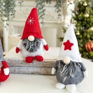Cute Christmas gnome plush dolls with snowflake embroidery on festive wooden background