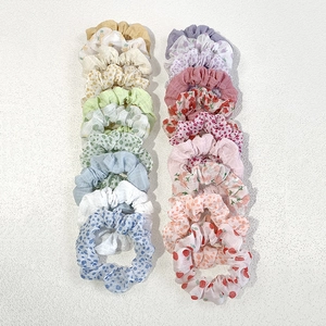 Flat lay view of assorted floral and polka dot chiffon hair scrunchies set on white background