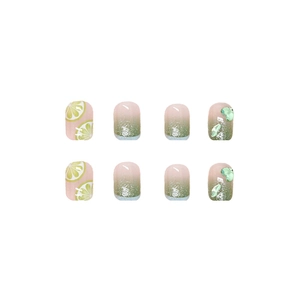 Press-on nails with green heart gems and lime patterns featuring a glitter finish