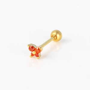 Macro shot of gold butterfly cartilage stud with orange cubic zirconia on white surface
