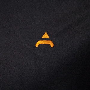 Close-up of black t-shirt fabric with premium orange geometric embroidery detail