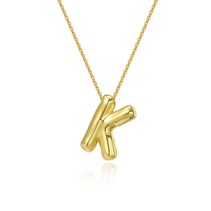 Macro view of polished 18K gold plated letter K pendant on a fine link chain