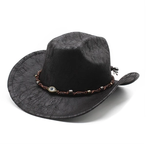 Dettaglio di cappello da cowboy vintage nero con texture screpolata e decorazione occhio