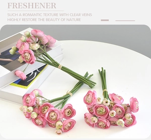Detailed view of artificial pink ranunculus bouquet and roses in a cozy home setting