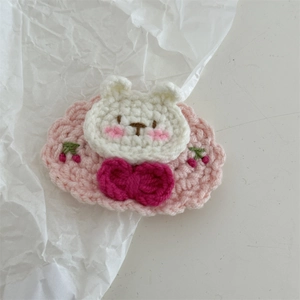 Detailed shot of handmade crochet bunny hair clip with cherry embroidery and pink bow