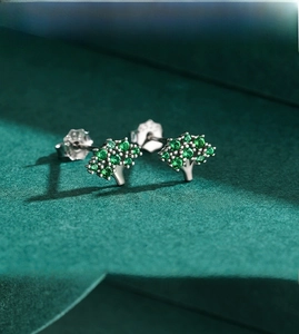 Macro shot of S925 silver tree stud earrings with emerald green cubic zirconia