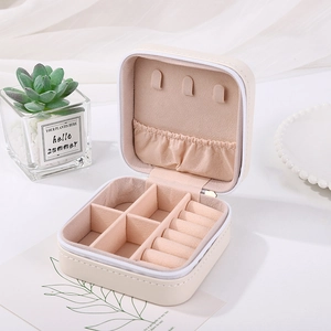 Close-up of portable jewelry box showing interior ring slots and hooks in cream finish