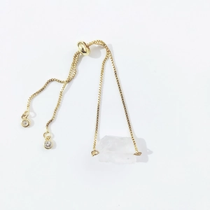 Detail view of the adjustable golden bolo bracelet with raw transparent crystal stone