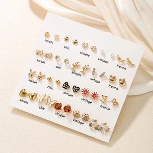 Detailed set of 30 pairs of gold-plated mini stud earrings on a white display card