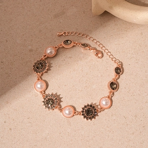 Bracelet vintage en or rose avec perles et strass tournesol sur fond de pierre
