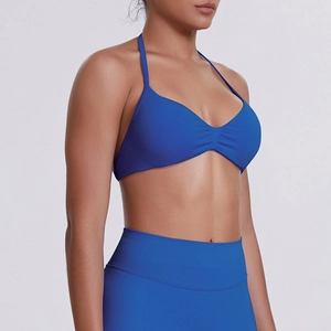 Detail of high-elasticity ribbed fabric on blue halter neck sports bra and leggings
