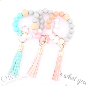 Detailed view of silicone bead keychain wristlets with tassels and beech wood accents
