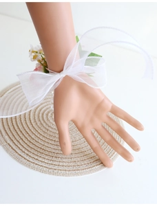 Gros plan d'un corsage de poignet rose et blanc avec rubans en organza sur tapis