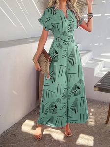 Detail of green V-neck jumpsuit with abstract print, waist belt and button features