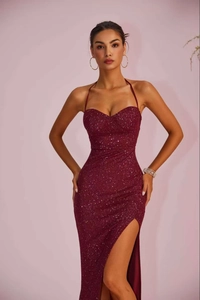 Detail of elegant burgundy sequin evening gown showing the high slit and slim fit design