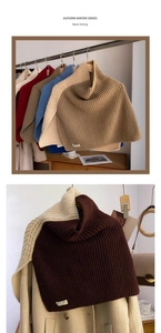 Detail of multi-color knitted turtleneck shawl with split hem showing soft textures