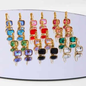 Set of 12 pairs of golden stud earrings with colorful square zircons on mirror