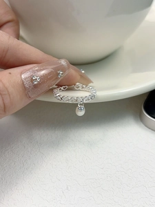 Close-up of S925 silver hollow heart ring with a freshwater pearl and rhinestone tassel