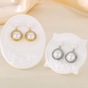 Détail de boucles d'oreilles perles style vintage français avec strass dorés et argentés