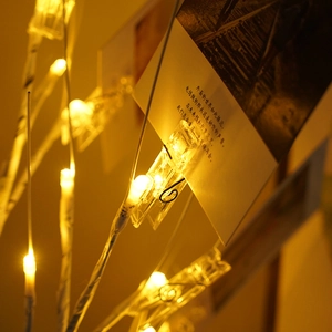 Macro shot of a warm LED photo clip on a white birch tree for holiday cards and decor