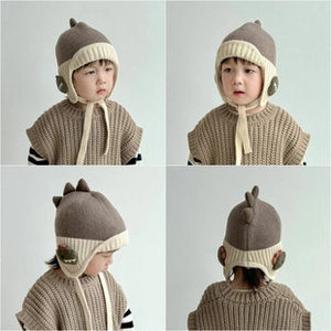 Detail view of knitted baby hat with dinosaur spine design and soft fabric texture