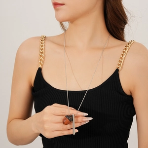 Close-up of a wooden acorn pendant with a silver bar on a delicate chain necklace
