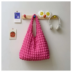 Detailed macro view of pink tote bag with bubble knit texture and soft fabric material