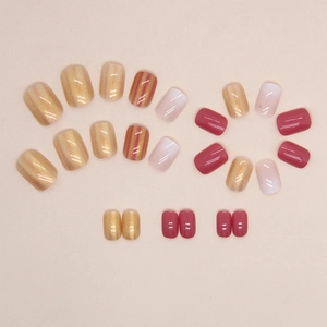 Short round press-on nails with golden glitter, magenta, and purple gradient colors