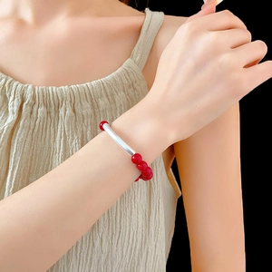 Bracelet ethnique en argent avec perles rouges sur poignet avec fond noir contrasté