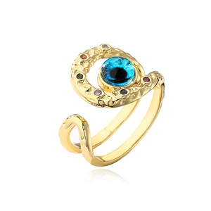 Macro detail of bohemian evil eye ring featuring blue stone and gold hammered texture