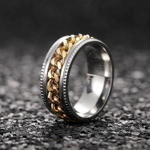 Macro detail of rotating cuban chain ring with silver gear edges and gold inner band