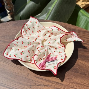 Floral cherry pattern scrunchie with red checkered bow on a ceramic plate decor