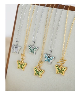 Vue détaillée des pendentifs papillon en émail coloré sur chaînes dorées et argentées
