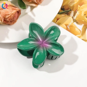 Detailed view of the flower hair claw clip with dark green and purple gradient petals