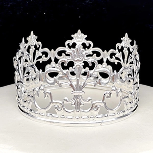 Close-up of intricate silver hollow crown featuring elegant fleur-de-lis patterns