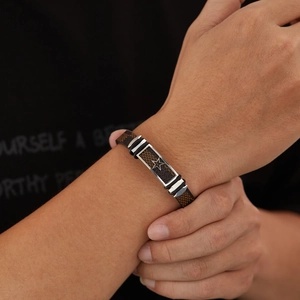 Men's brown leather bracelet with star pattern and vintage texture on model's wrist