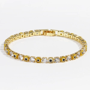 Detail of gold tennis bracelet featuring yellow evil eye beads and clear cubic zirconia