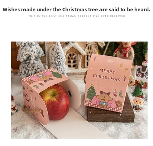 Detailed view of pink Christmas gift box with reindeer print and gold rope handle