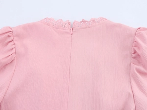 Detail of pink dress back featuring lace trim V-neck and invisible zipper closure